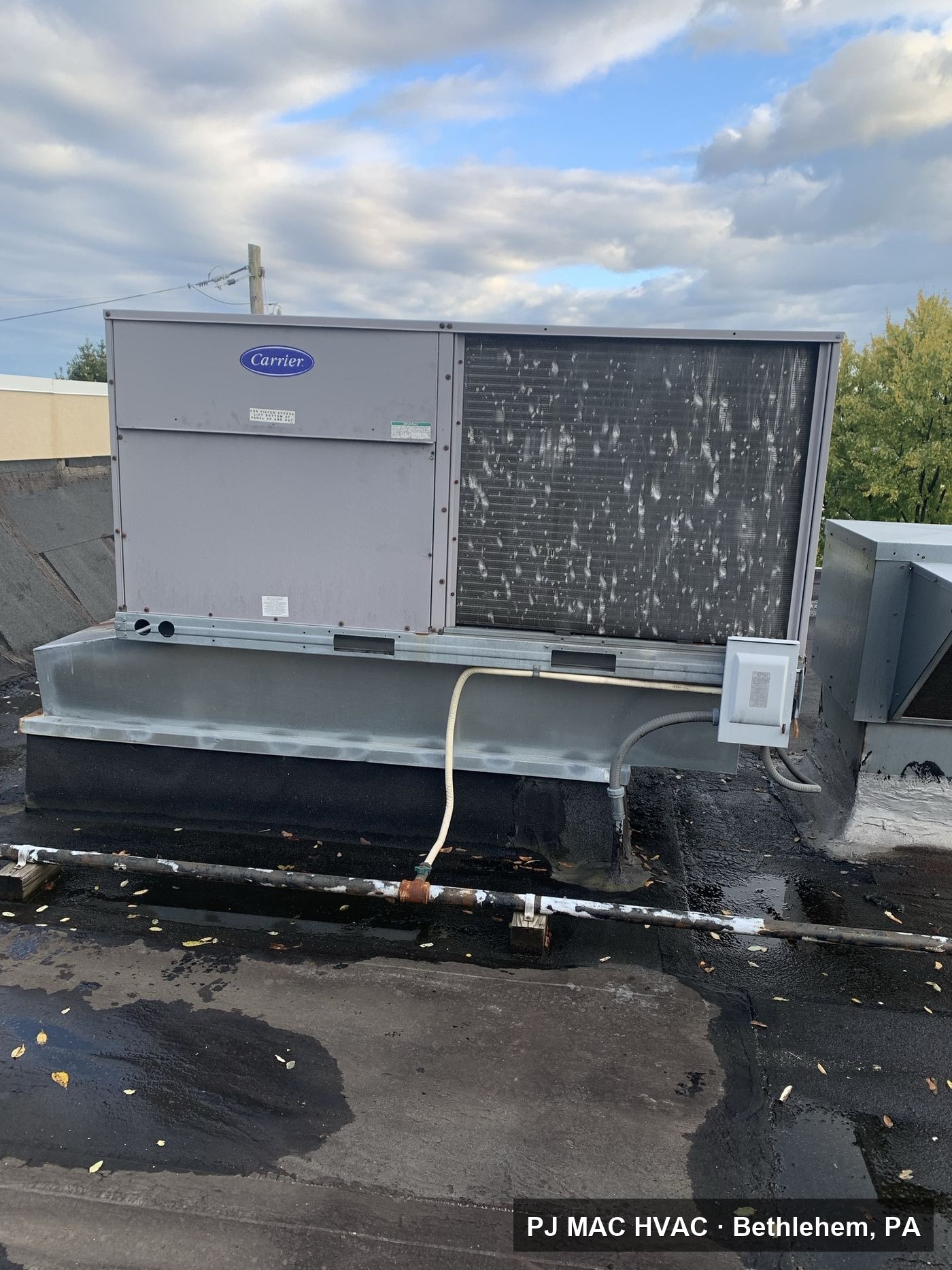 A Carrier commercial rooftop unit installed and serviced by PJ MAC HVAC on a Philadelphia-area business.
