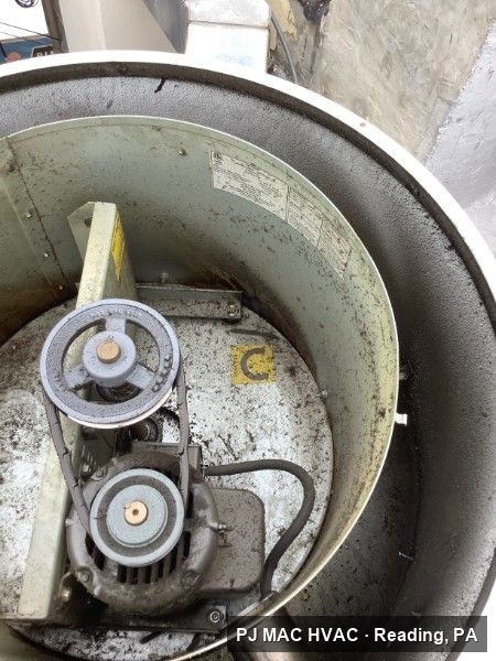 PJ MAC HVAC services the belt-drive motor inside a commercial rooftop exhaust fan.