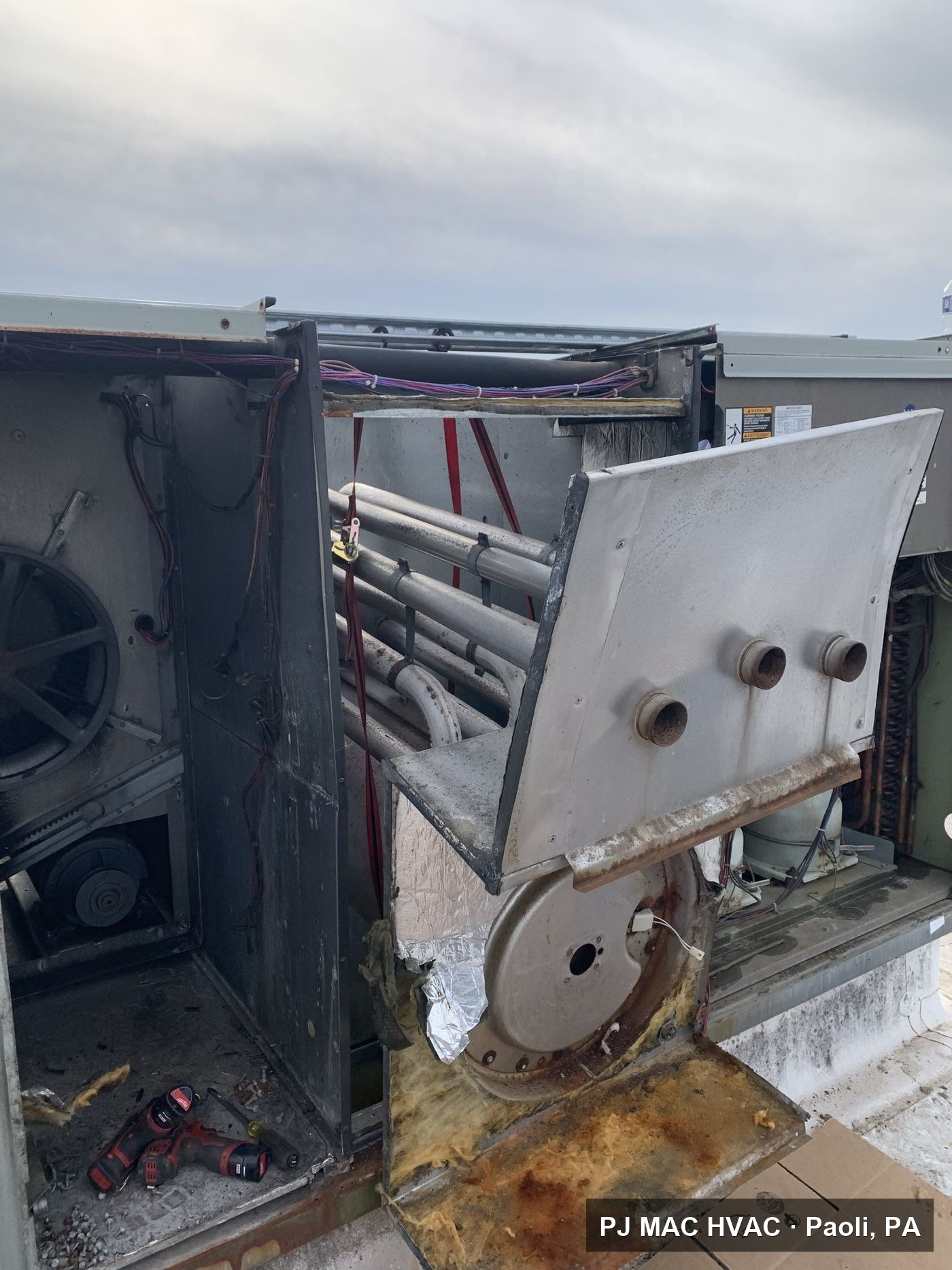 A commercial rooftop unit opened up by PJ MAC HVAC during a heat exchanger replacement.